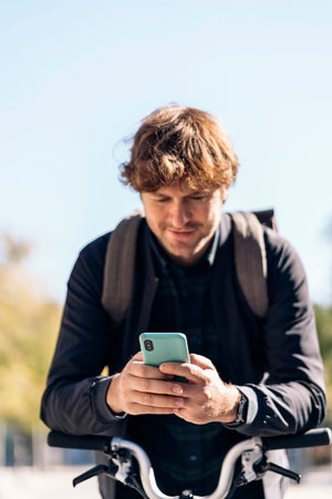 Stock photo of handsome man using his cellphone in the street.