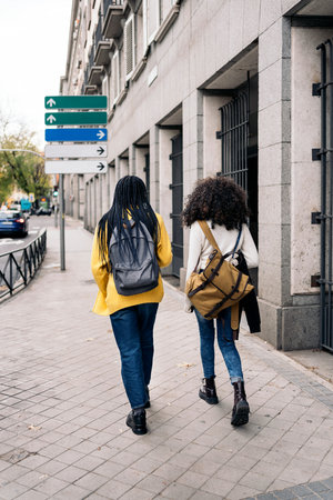 Stock photo of unrecognized afro girls walking in the city.