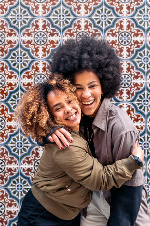 Stock photo of lovely afro girls hugging each other and looking at camera.の写真素材