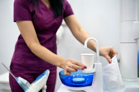 Stock photo of unrecognized worker in dental clinic using water dispenser.の写真素材