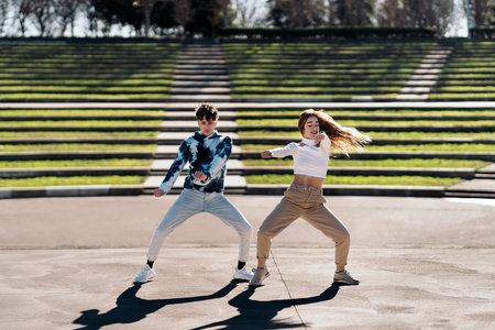 Stock photo of happy girl and her friend practicing their dance moves and having fun.