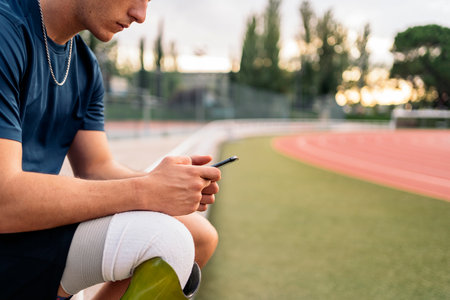 Disabled man athlete using his phone while doing a break.の写真素材