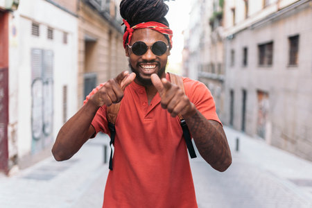 Stock photo of happy african american boy with dreadlocks and a bandana walking in the street.の写真素材