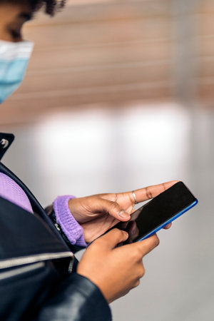 Stock photo of unrecognized woman using mobile phone in train station.の写真素材