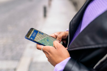 Stock photo of unrecognized afro woman looking at a map in her phone.の写真素材