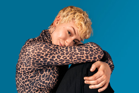 Stock photo of expressive girl wearing animal print shirt looking at camera and smiling.の写真素材