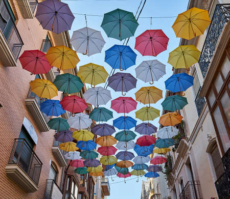 colorful umbrellas adorn the streetsの写真素材