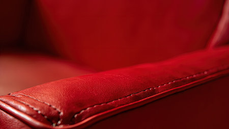 Experience the luxurious detail of this close-up shot featuring a vibrant red leather armrest. The image showcases intricate stitching and a rich texture, highlighting the craftsmanship of the upholstered piece. Perfect for interior design projects, this elegant and modern image evokes a sense of luxury. Its bold color and tactile surface make it ideal for marketing furniture, sofa, and chair designs. This close-up offers a detailed view of the seam and pattern, a visually compelling background for various applications.の素材