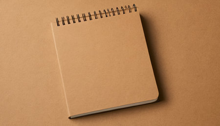 Top view of brown notebook isolated on brown background with copy space.の素材