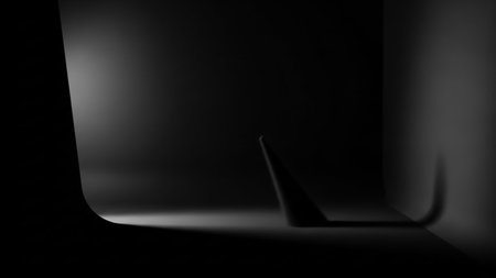 A dark, abstract studio scene with dramatic lighting. A single spotlight illuminates a small cone-shaped object, casting a long, curved shadow on the floor and wall. The composition is minimalist and moody, with strong contrasts between light and shadow, creating a sense of depth and mystery.の素材