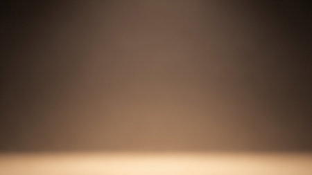 A softly lit studio background with a smooth gradient transitioning from a darker brown at the top to a lighter, warmer beige at the bottom. The lighting is diffused, creating a gentle glow and a subtle sense of depth. This minimal and warm-toned backdrop is ideal for product photography or creating a cozy atmosphere.の素材