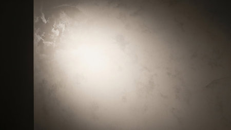 A textured background with a bright, diffused light source emanating from the center, fading into darker tones towards the edges. The surface appears slightly weathered or aged, with subtle variations in color and texture creating a soft, atmospheric effect. The dark left side creates a strong vignette, drawing attention to the illuminated area.の素材