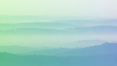 A serene landscape of rolling hills and mountains shrouded in thick mist. The scene is rendered in soft, gradient hues of green, blue, and purple, creating a tranquil and atmospheric effect. Layers of fog obscure the distant peaks, emphasizing the depth and vastness of the natural environment.の素材