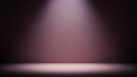 An empty stage with a soft pinkish-purple gradient background. A bright spotlight shines down from above, creating a luminous beam that illuminates the floor. The edges of the image are dark, creating a dramatic and atmospheric effect.の素材
