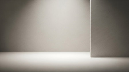 A minimalist interior space with smooth, neutral-colored walls and floor. Soft, diffused light creates subtle shadows, highlighting a corner element. The scene is clean, simple, and abstract, offering a blank backdrop with a subtle geometric form.の素材