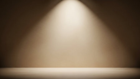 A simple, atmospheric background with a single, soft spotlight illuminating a textured wall and floor. The light creates a warm gradient from bright white at the top to darker shades of brown and beige, casting subtle shadows and creating a sense of depth.の素材