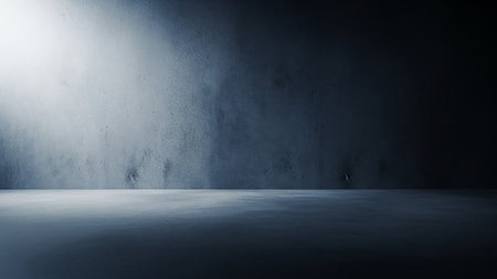 A dark, textured concrete studio with a stark spotlight illuminating the wall and floor, creating a dramatic and moody atmosphere.の素材