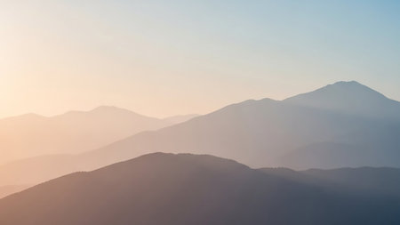 Layered mountain peaks in soft pastel hues of orange, pink, and blue during sunrise or sunset, creating a serene atmosphere.の素材