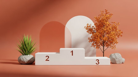 A white podium with numbers 1, 2, and 3 is displayed with an autumn tree and potted plant against a terracotta background.の素材