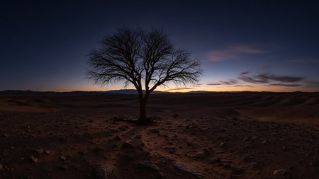 A solitary bare tree stands in a vast desert landscape at twilight, with rolling sand dunes stretching towards the horizon under a darkening sky.の素材