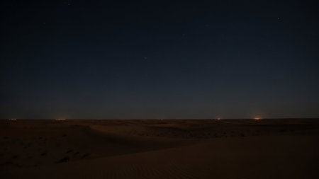 Serene showing vast dark desert landscape at night with distant city lights on the horizon and starry sky keywords: desert, landscape, night, dark, starry sky, stars, horizon, distant...の素材
