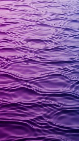 A close-up view of a water surface displaying gentle ripples and a smooth gradient transitioning from deep purple to vibrant pink.の素材