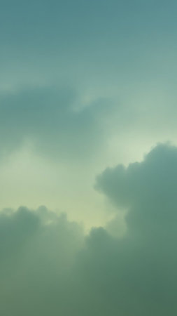 A soft, atmospheric sky with blended teal and yellow hues, featuring diffused clouds creating a tranquil and serene backdrop.の素材