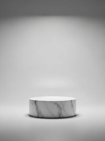 A white cylindrical marble pedestal with gray veining sits on a gray surface, illuminated by soft studio lighting creating subtle shadows.の素材