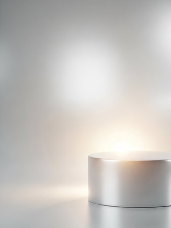 A minimalist silver cylinder podium with soft, warm light and a blurred bokeh background, ideal for product display or presentation.の素材