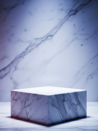 A clean white marble cube sits on a matching marble surface, set against a softly lit, marbled background with subtle grey veining.の素材
