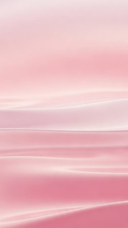 Soft pink fabric flows in gentle waves with subtle light reflections creating a smooth and elegant abstract background.の素材