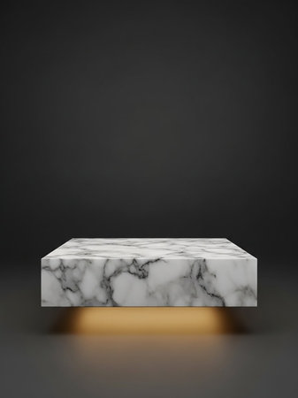 A rectangular white and grey marble pedestal with visible veins, illuminated by a warm golden light from beneath, set against a dark background.の素材