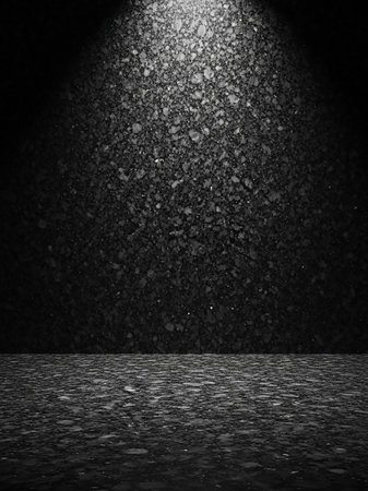 A dark, textured asphalt surface with a spotlight illuminating the top, creating a dramatic and gritty background effect.の素材