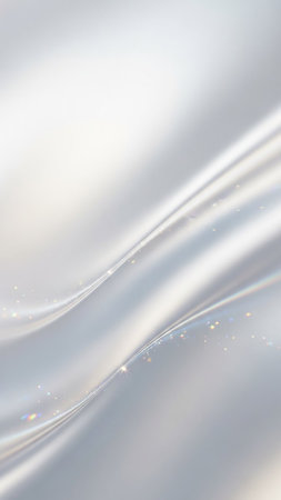Soft, flowing white silk fabric with subtle light reflections and scattered glittering particles creates an elegant and delicate abstract background.の素材