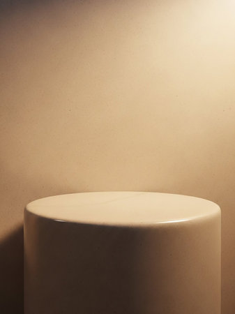 A smooth, beige cylindrical display stand is softly lit against a textured neutral background, creating a clean and minimalist presentation space.の素材