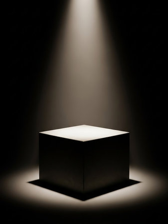 A dark room features a square pedestal dramatically illuminated by a single, focused spotlight from above, casting shadows.の素材