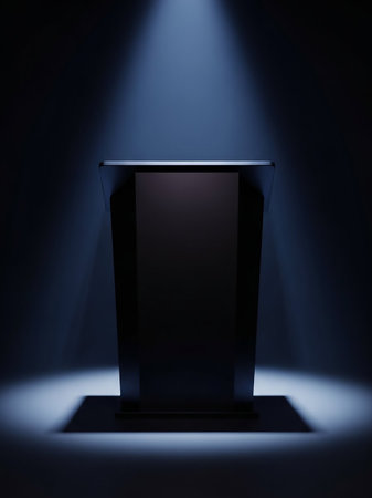 A dark, modern podium stands center stage, dramatically lit by a single, focused spotlight from above, casting a shadow on the floor.の素材