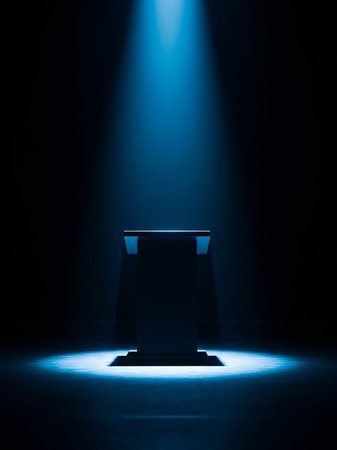 A dark, empty podium stands on a stage, bathed in the dramatic glow of a single, bright blue spotlight from above, casting long shadows.の素材