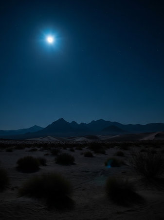 A wide desert expanse is bathed in the bright light of a full moon. Silhouetted mountain ranges form a dark line against the deep blue night sky dotted with stars, creating a serene and vast...の素材