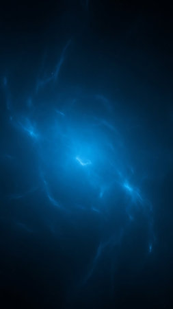 An ethereal blue nebula glows with bright light, surrounded by wispy cosmic tendrils against a dark, deep space background.の素材