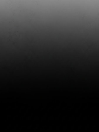 A deep black background with subtle grey speckles and a gradient from light grey to black, creating a dark and textured abstract backdrop.の素材