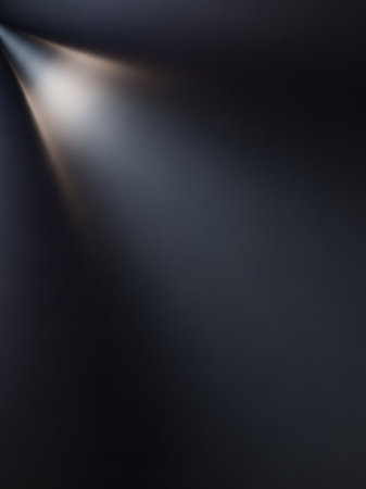 Beam showing a subtle spotlight beam illuminates a dark, textured surface with a soft gradient of light and shadow creating a dramatic and moody atmosphere...の素材