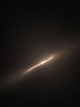 A bright, glowing light streak curves across a dark, hazy background, creating an abstract and ethereal luminous effect.の素材