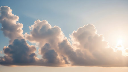 Soft white cumulus clouds are brightly illuminated by sunlight against a clear light blue sky, with subtle sun rays visible.の素材