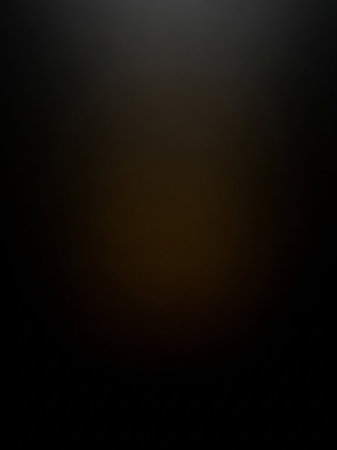 A dark, abstract background subtle gradients of deep brown and black, creating a moody and mysterious visual texture.の素材