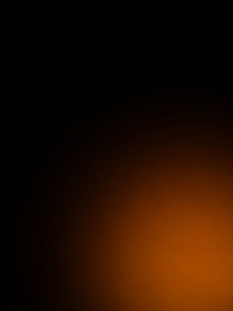 A gradient transitions from black on the left to a warm orange on the right, with a soft focus and a subtle light flare.の素材