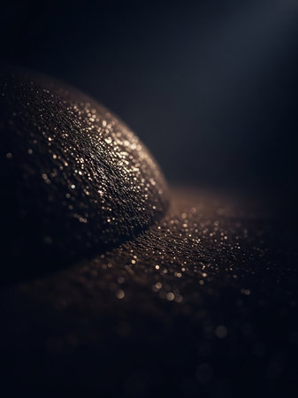 Stock showing close up macro shot of skin texture covered in tiny water droplets or sweat reflecting golden light in dark moody lighting with soft bokeh effects....の素材