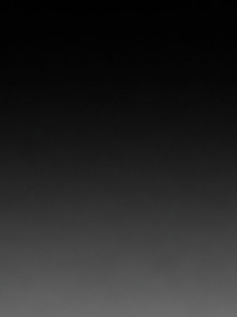 A smooth gradient from dark grey to black, with a very subtle texture and a slightly lighter, diffused area at the bottom.の素材