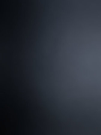 A dark navy blue and gray gradient background a smooth transition with a subtle lighting effect, creating a and muted tone.の素材