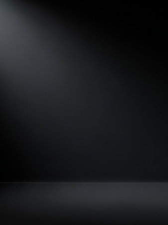 A dark gray studio background a subtle spotlight from the left, casting a soft reflection on the floor below.の素材